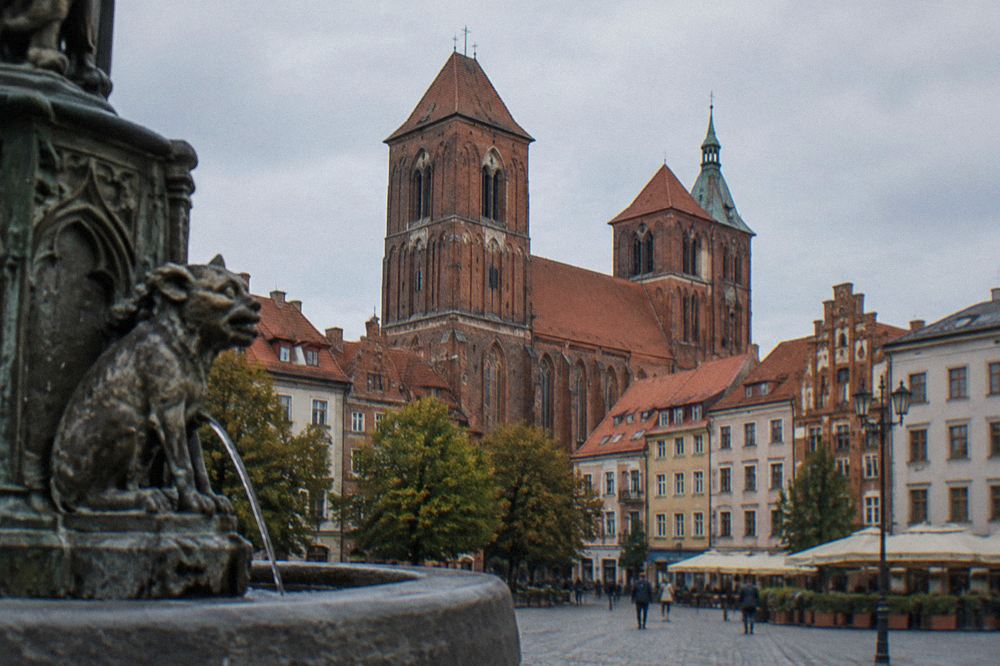 Red brick Gothic church towers rising over the roofline of the medieval Old Town of Toruń