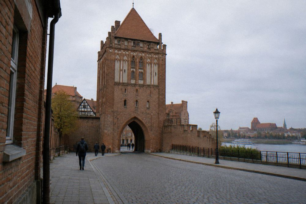 Gothic gate tower of the Toruń city walls seen from the street