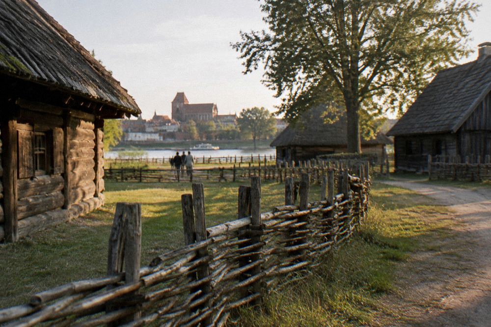 Traditional rural fence and timber buildings in the open-air park of the Toruń ethnographic museum