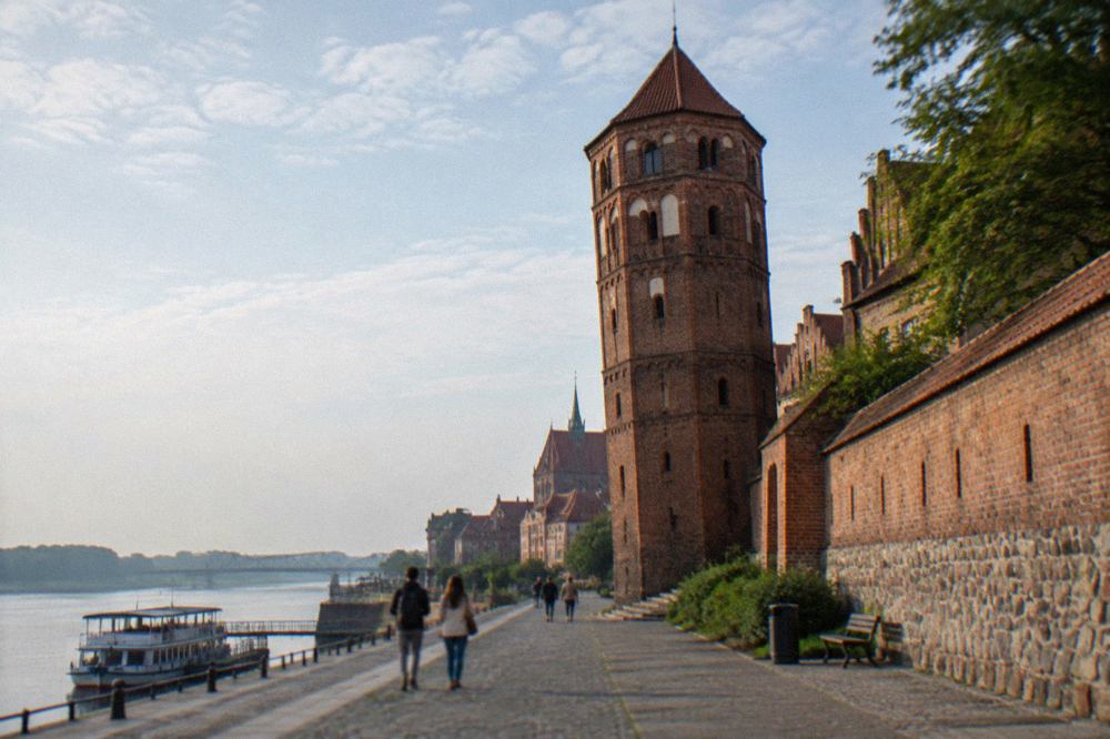 The leaning tower of Toruń rising from the medieval brick town wall on ul. Pod Krzywa Wieza