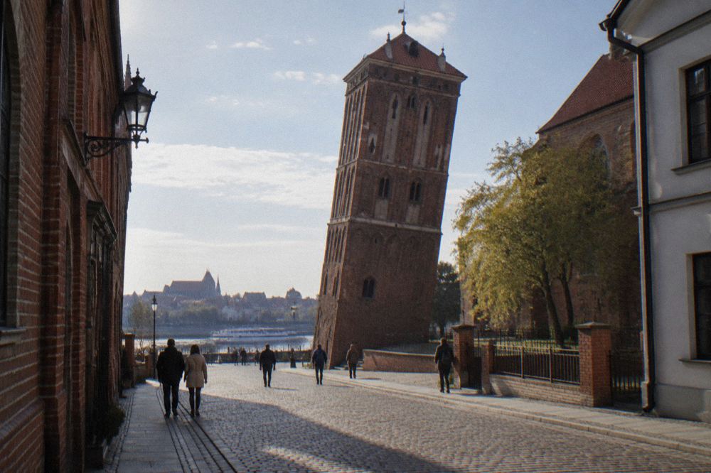 Detail of the tower's tilt seen from the cobbled street on ul. Pod Krzywa Wieza