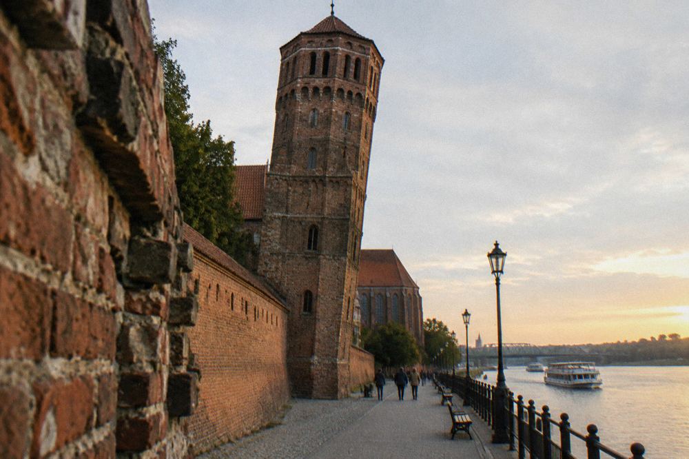The Leaning Tower of Toruń with the brick wall running along the street on the Vistula side