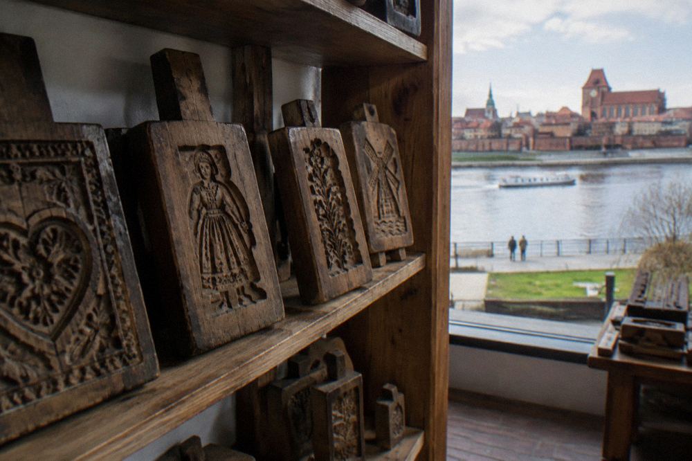 Wooden gingerbread moulds with carved patterns displayed on a shelf