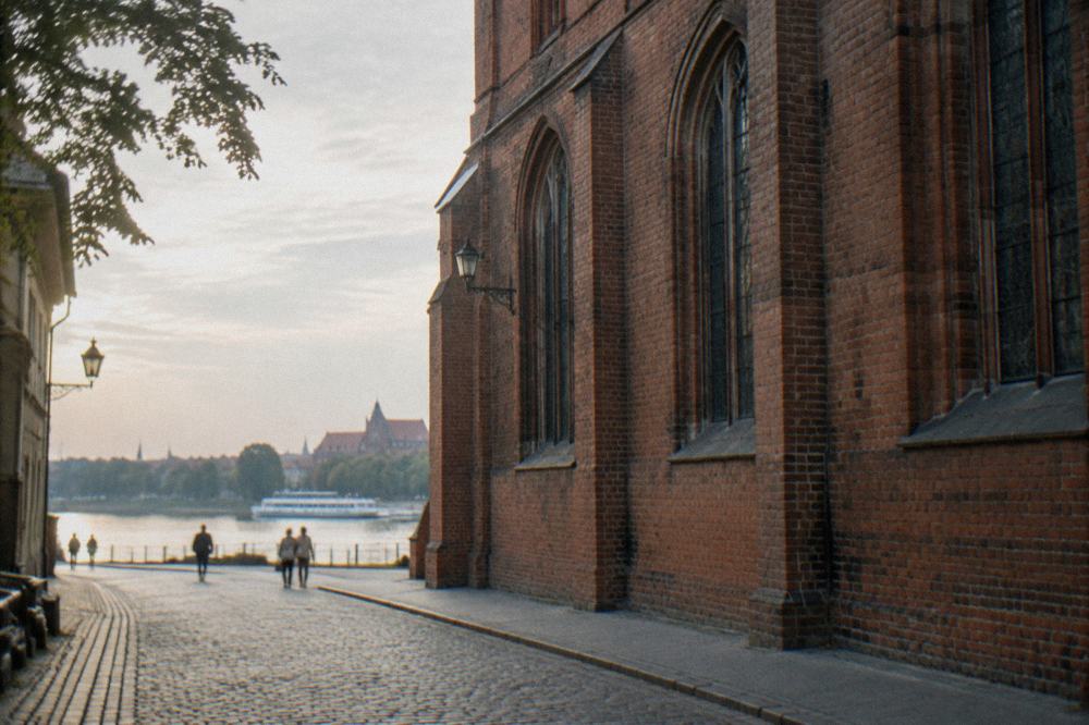 Brick Gothic church wall seen from a quiet Old Town street with no tower on the building
