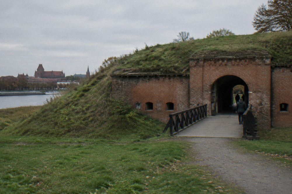 A grass-covered fort earthwork with a brick entrance passage