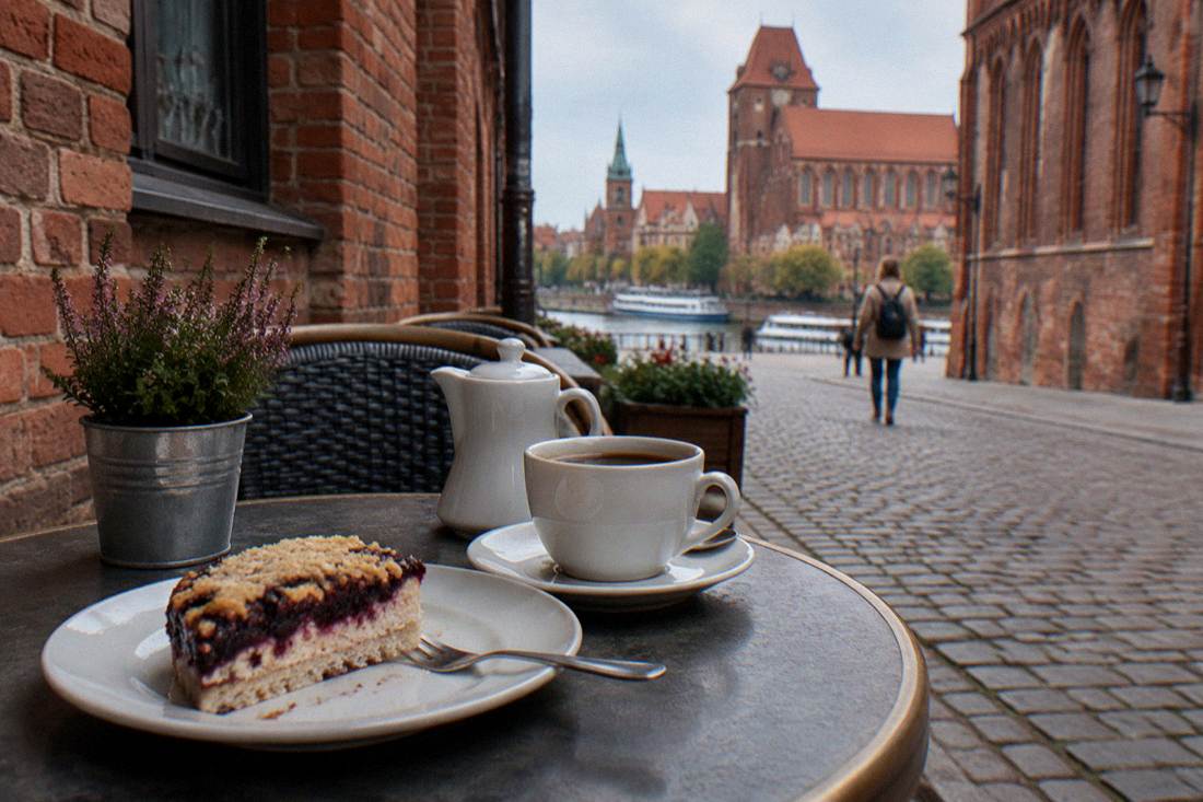 A cafe terrace with cake and coffee on a narrow Old Town street