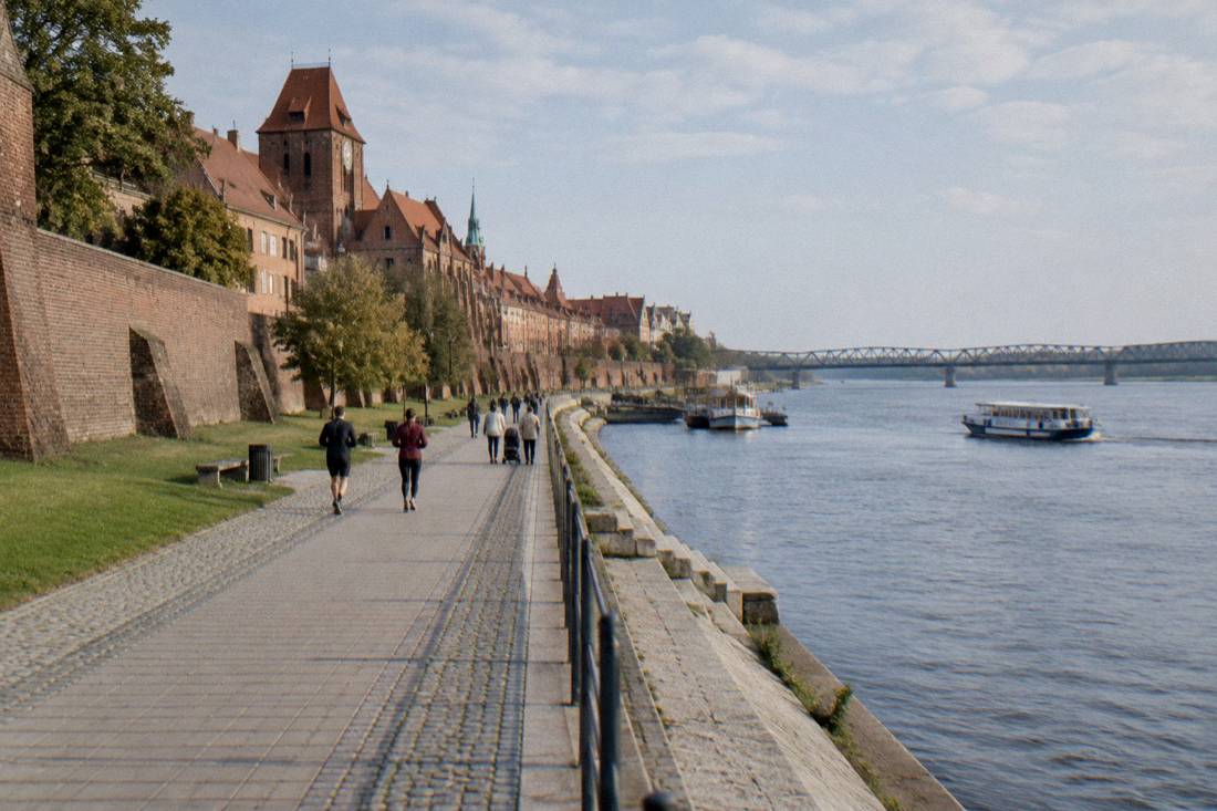 A free riverside walk along the stone embankment in Toruń