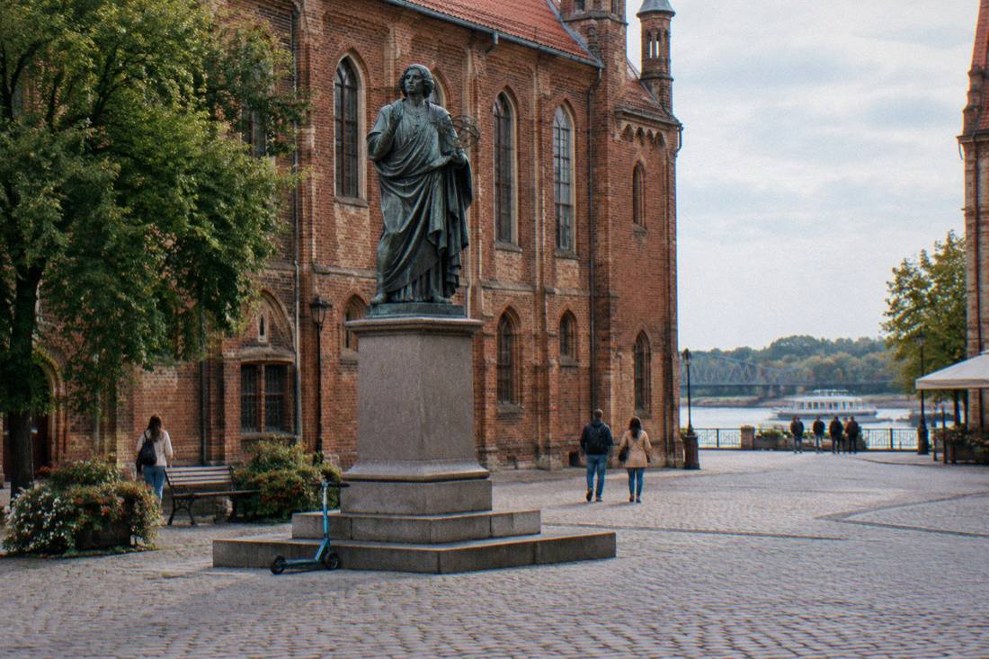The bronze Copernicus statue on its stone plinth in Toruń's Old Town square