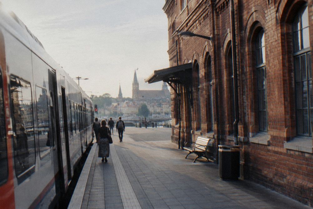 A passenger train standing at a platform beside a brick station building
