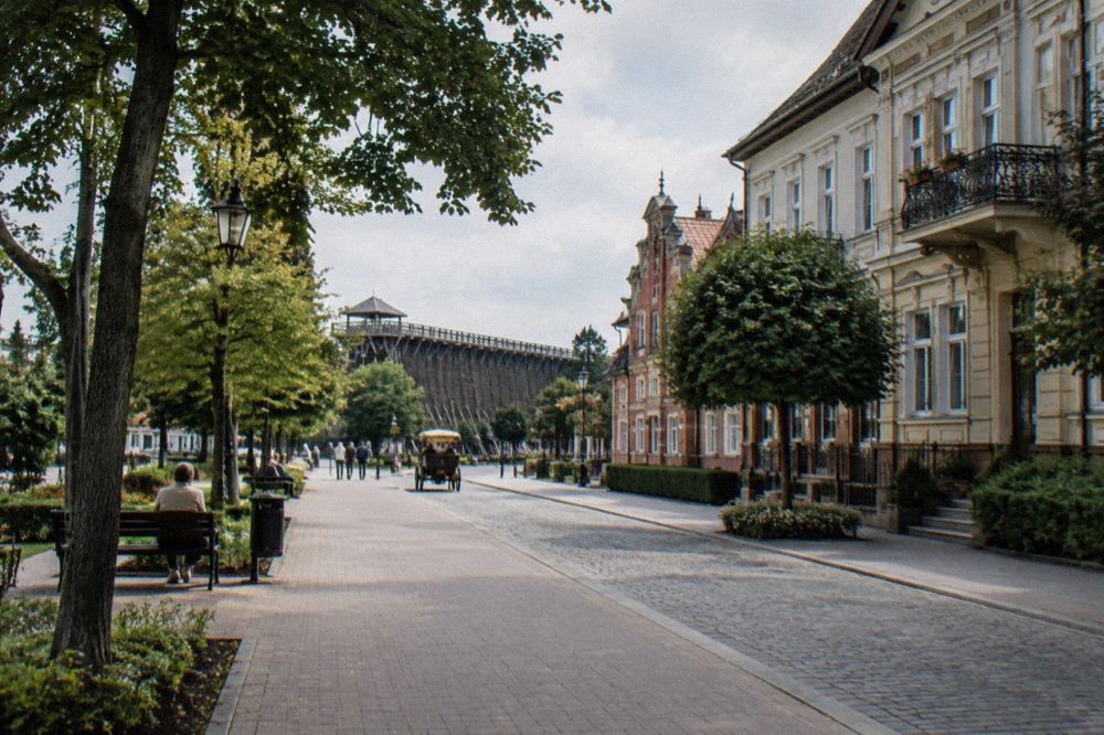 A spa town street with trees and period buildings in Poland