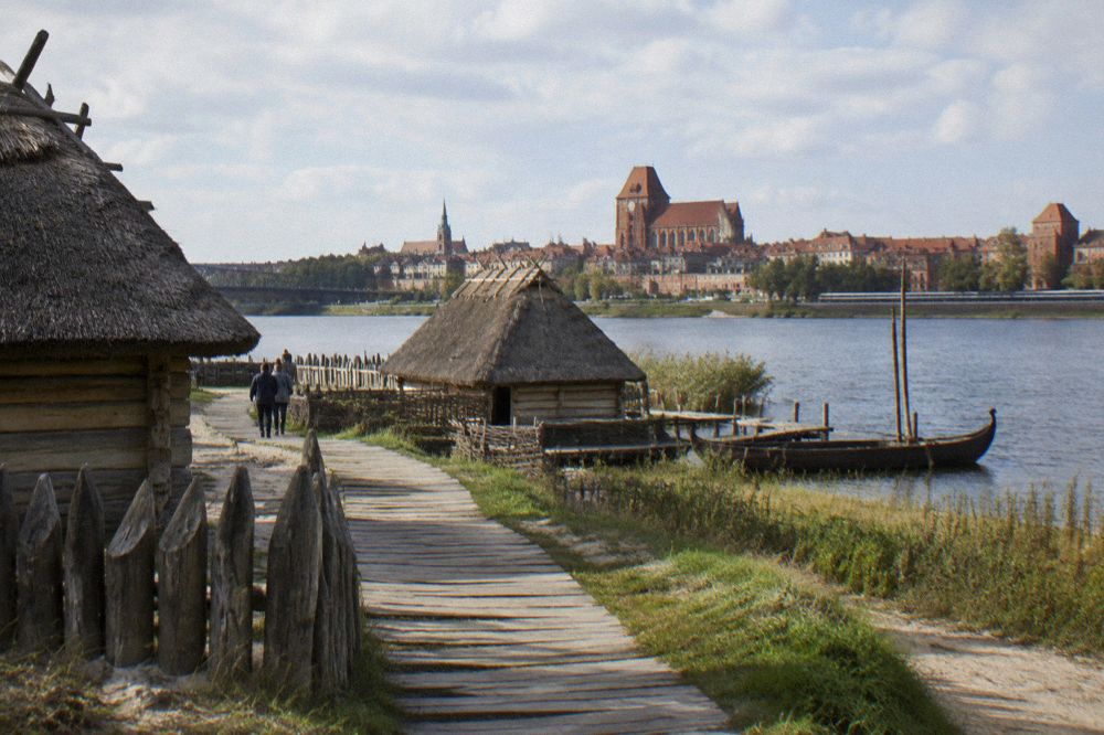 Reconstructed wooden prehistoric settlement buildings on a lakeshore peninsula