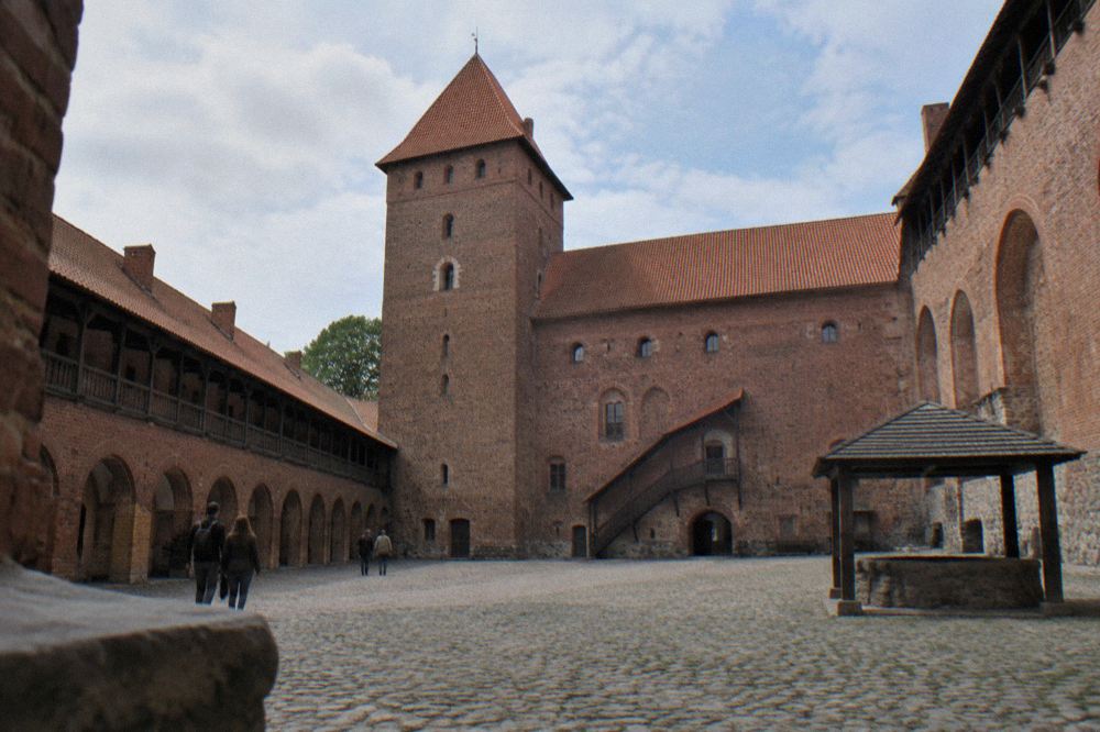 The castle courtyard seen from below, enclosed by high brick walls and arcades