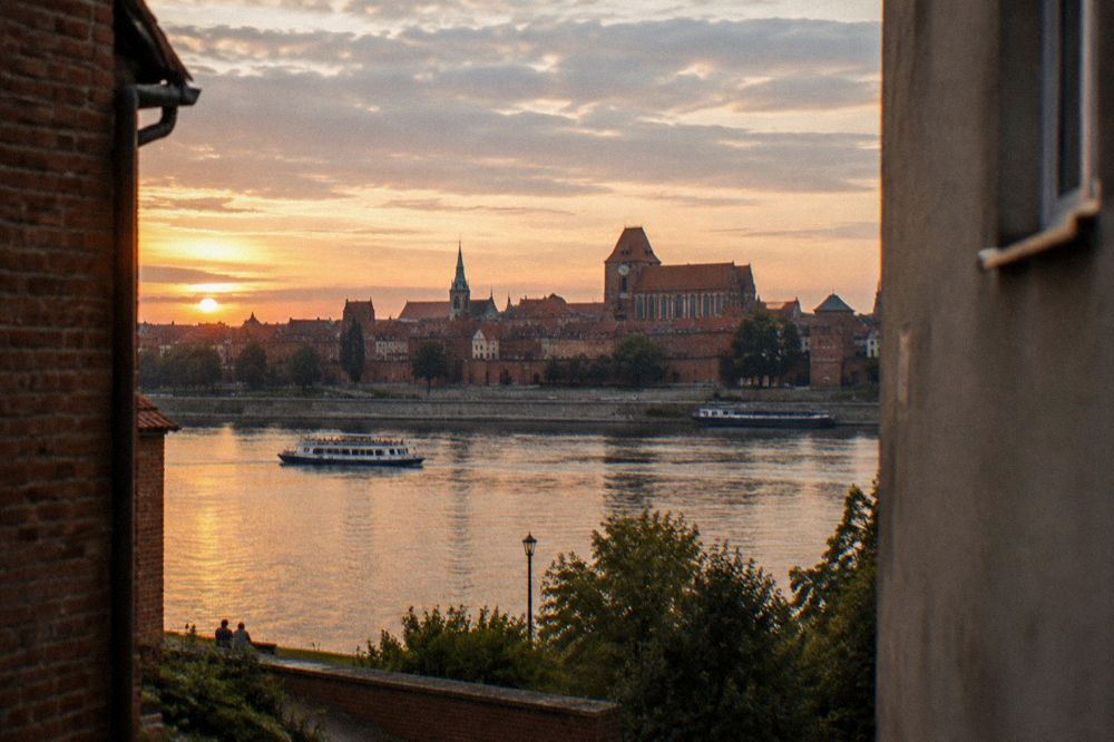 The Vistula river and Toruń Old Town skyline at sunset seen from the far bank