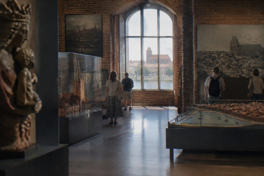 Visitors walking through museum exhibition halls in a Toruń museum