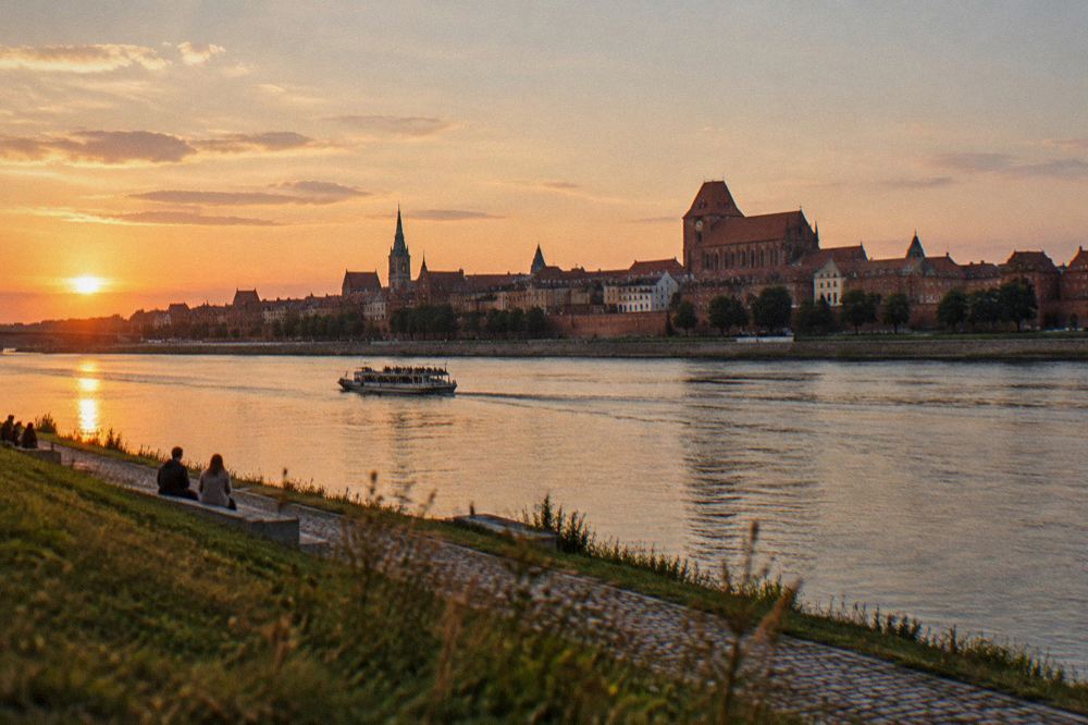 The Vistula river and the skyline of Toruń's Old Town seen from the left bank at sunset