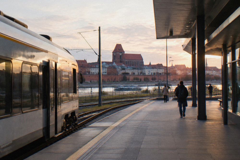 A train standing at a platform beside a modern Polish railway station