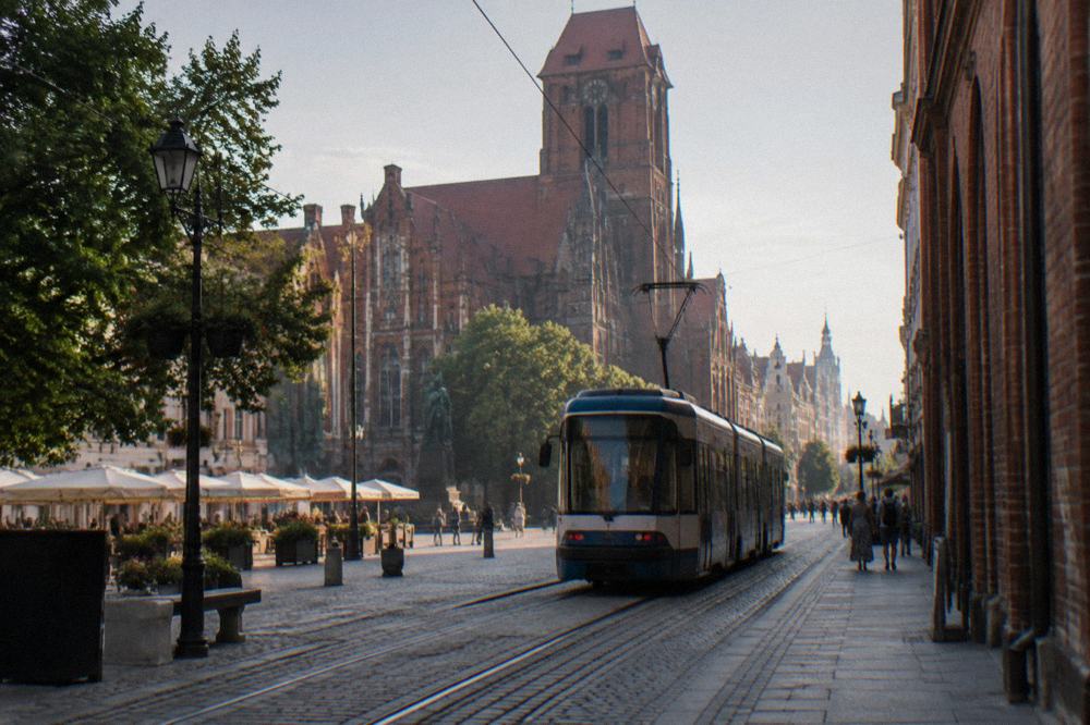 A tram moving along a street in central Toruń