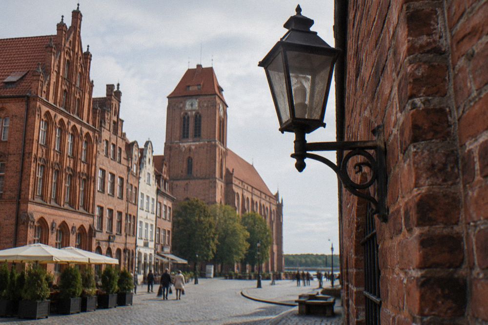 Cobbled street in Toruń Old Town with brick Gothic townhouses in daylight