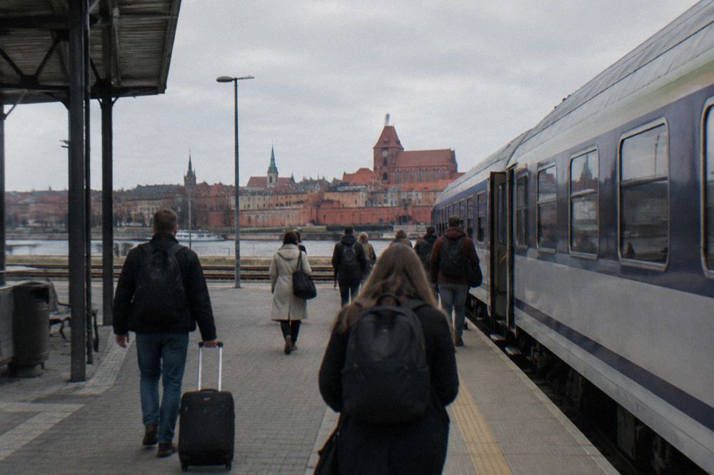 Passengers walking along a station platform toward an intercity train
