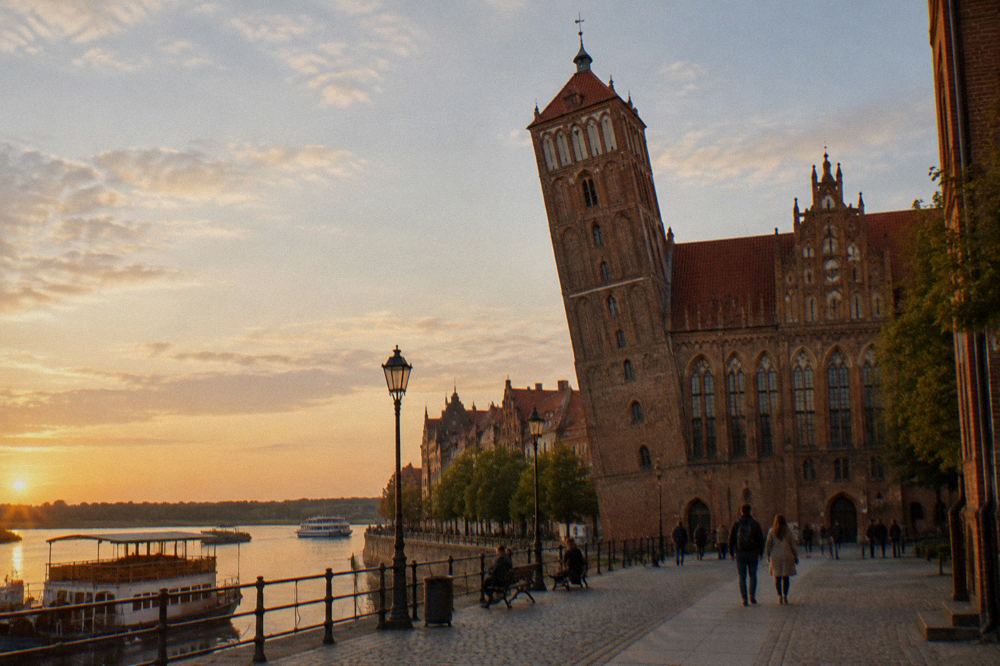 The leaning Gothic tower on ul. Pod Krzywa Wieza in Toruń with its distinct tilt visible against the sky