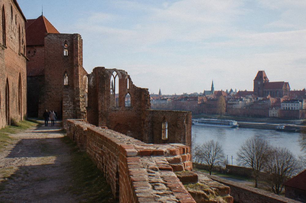 Medieval brick buildings and a church tower rising above the old town of Toruń