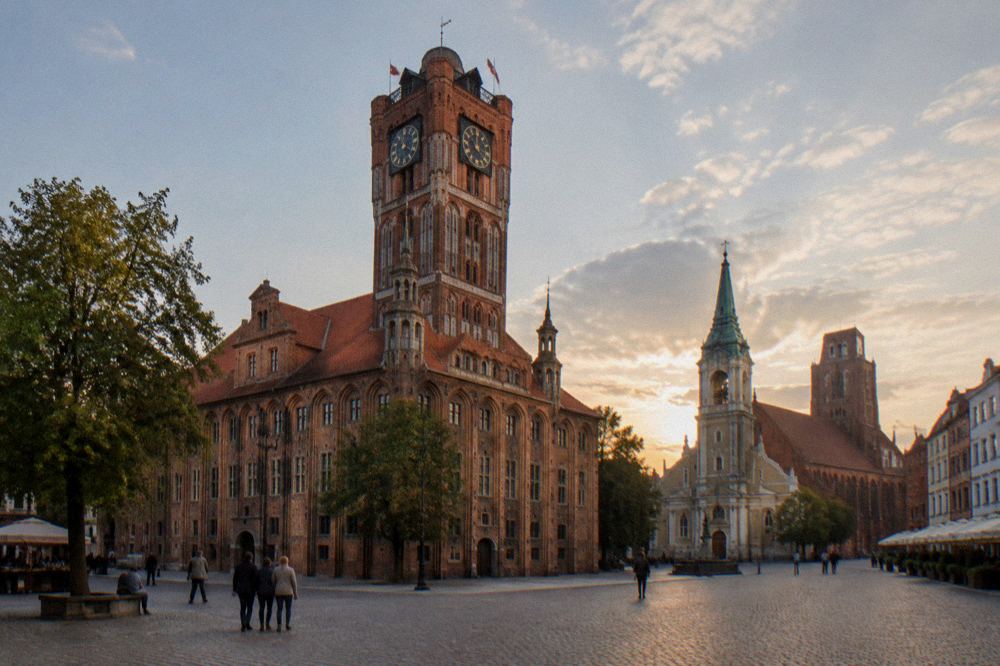 The old town market square of Toruń with a brick town hall and Gothic church towers