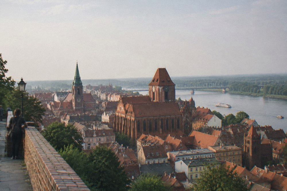 Panoramic view over the red rooftops and church towers of the Old Town of Toruń from a tower terrace