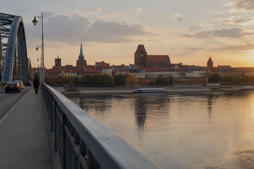 The Vistula river seen from a bridge with the towers of Toruń Old Town on the far bank