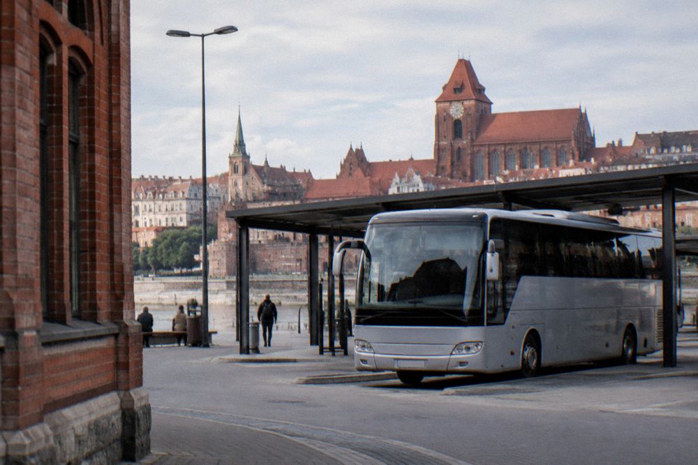 A long-distance coach parked at a bay of a city bus station in Poland