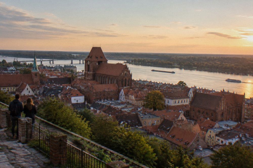 Panoramic view over Toruń Old Town rooftops with the Vistula river beyond