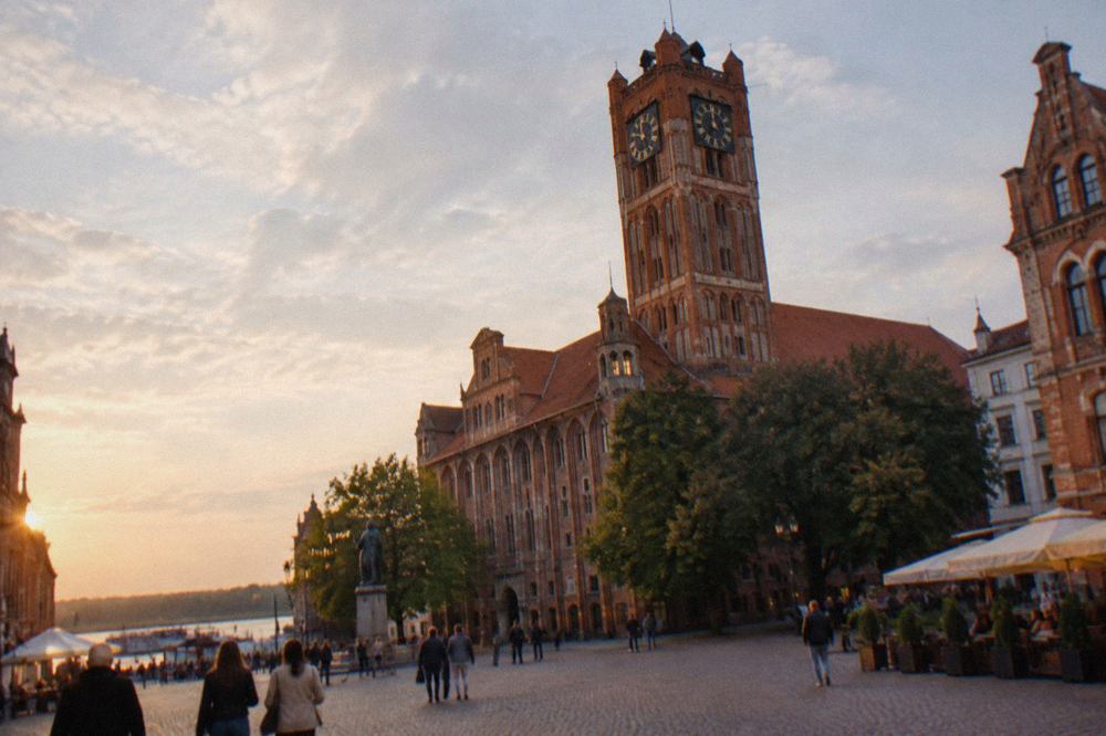 Gothic brick town hall tower rising above a medieval market square