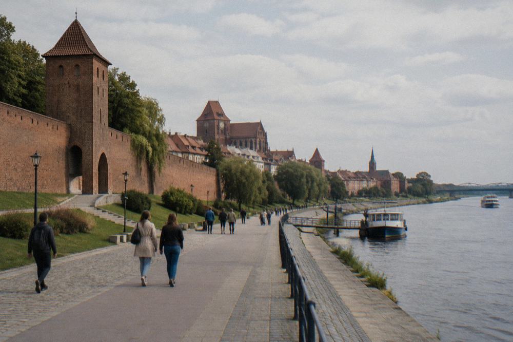 People strolling along Philadelphia Boulevard below the medieval town walls beside the Vistula river
