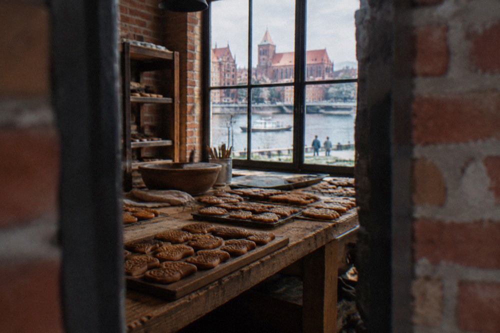 Freshly baked Toruń gingerbread cookies arranged on a wooden table in a bakery