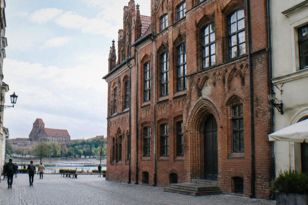 Gothic brick townhouse facade on a street in Toruń Old Town