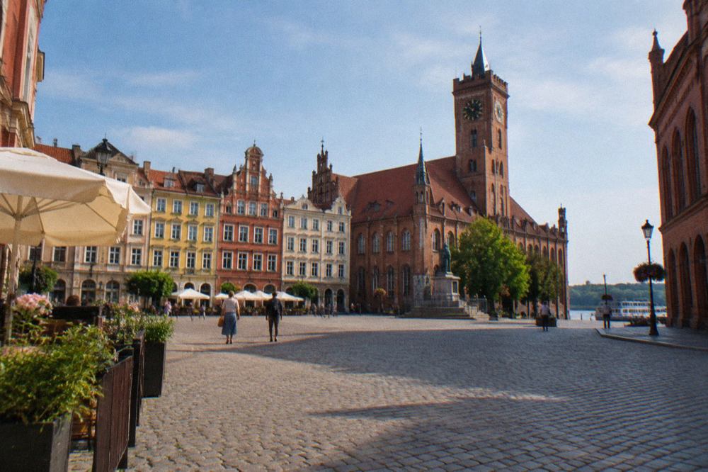 Colourful Gothic townhouses of Toruń Old Town around a cobbled market square under a blue sky