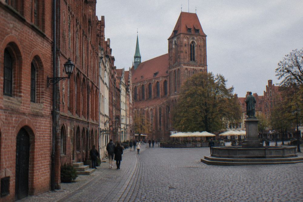 A cobbled street of Gothic brick townhouses in Torun Old Town seen in morning light