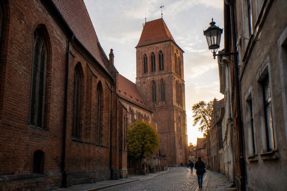 The brick tower of the cathedral of Saints John in Torun seen from a narrow street