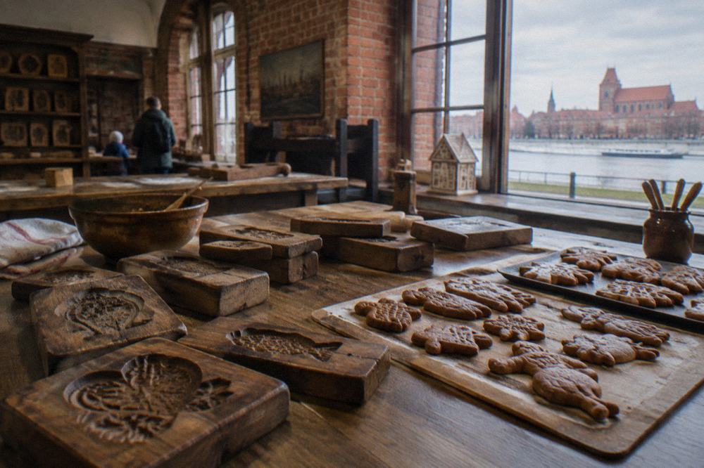 A table with wooden gingerbread moulds and freshly baked spiced cookies in a museum workshop room