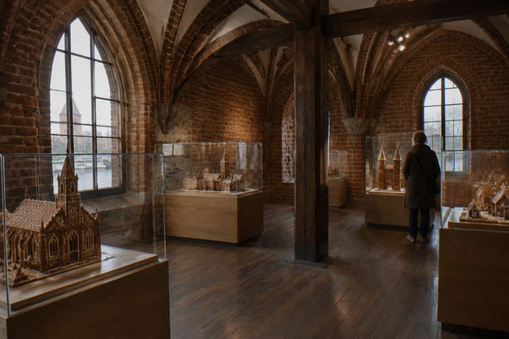 Children watching a gingerbread baking demonstration inside a historic Toruń museum