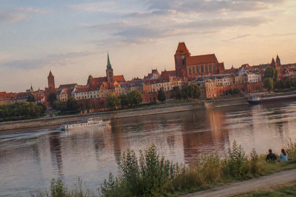 Panoramic view over the red brick roofs and church towers of the Toruń Old Town seen from the opposite bank of the Vistula River