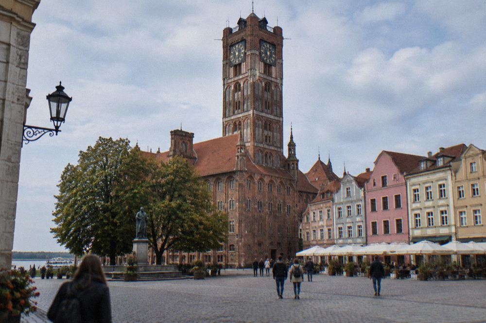 Gothic brick Old Town Hall tower rising above the colourful burgher houses of the main square in Toruń